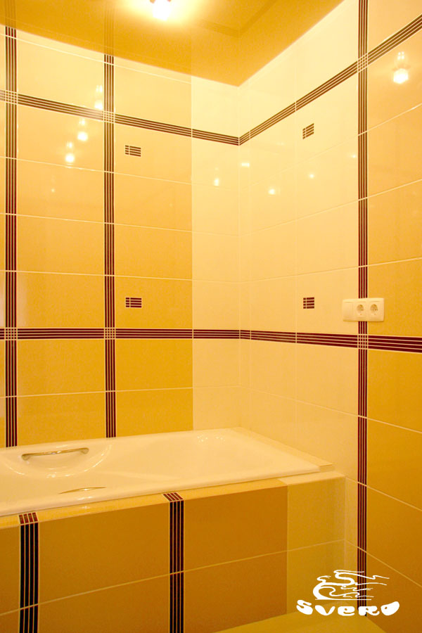 Ванная комната. Натяжной глянцевый потолок. Экран ванны облицован плиткой.